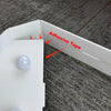 A white marquee light-up letter is shown with adhesive tape being applied to the back for mounting.