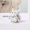 A white crystal sculpture shaped like a fox head with gold accents, displayed on a white surface.