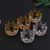 A collection of five ornate crown-shaped cake toppers and hair accessories made of gold and silver metal with colored gems