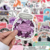 A hand holds a clear jar of purple and pink reading stickers on a colorful background.