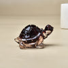 Eine kleine, dunkelbraune Kristallfigur in Form einer Schildkröte als Heimdeko.