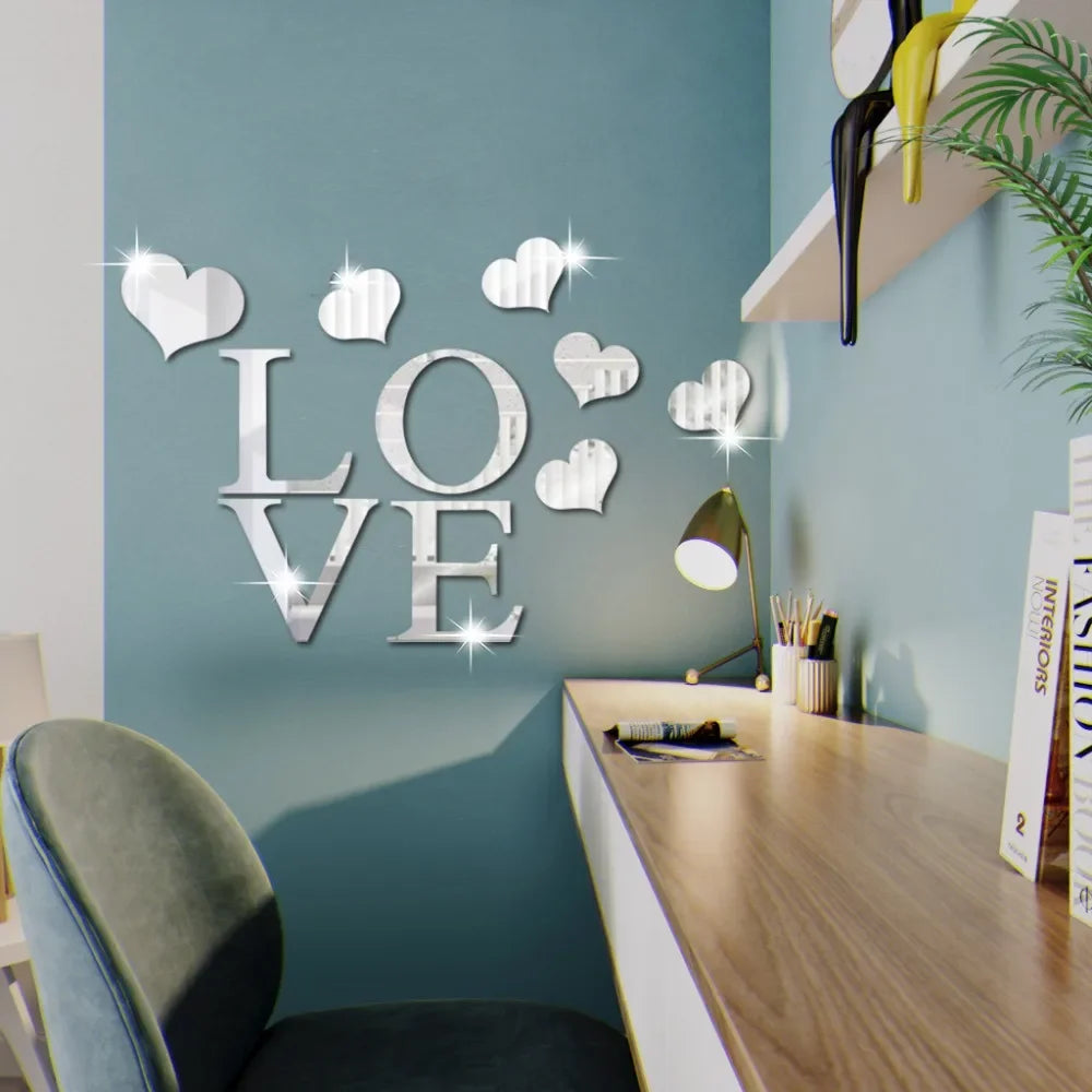 Silver acrylic heart wall stickers displayed on a teal wall above a wooden desk.