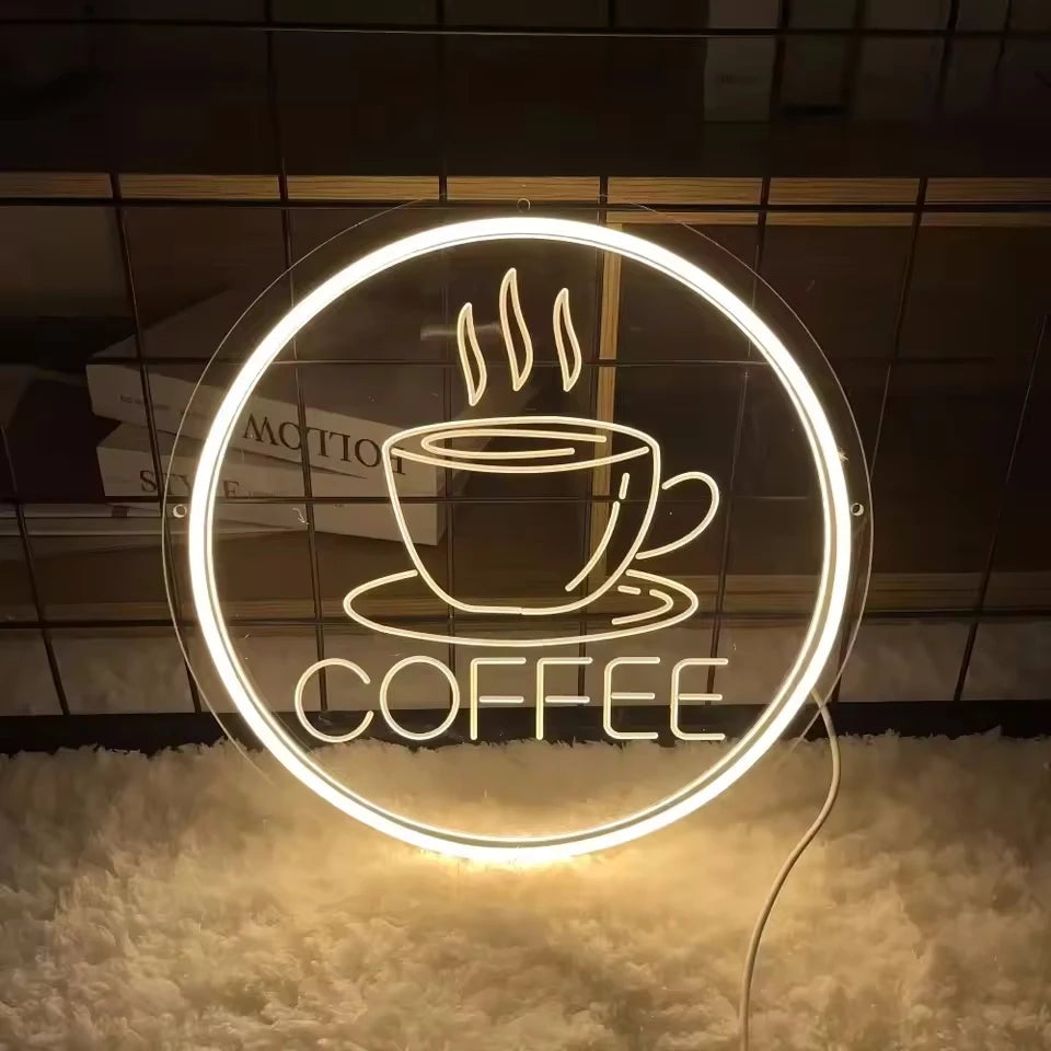 A circular neon sign featuring steam above a cup and the word COFFEE on a dark background.