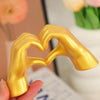 A golden heart hand sculpture is held by a hand, showcasing a romantic love statue for home decor and gifting.