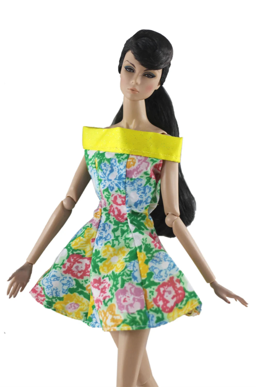 A handmade doll dress gown featuring a floral print and a yellow sash on a black-haired doll.
