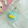 A fluffy turquoise plush toy shaped like a yellow sausage with a mouth, attached to a silver chain.