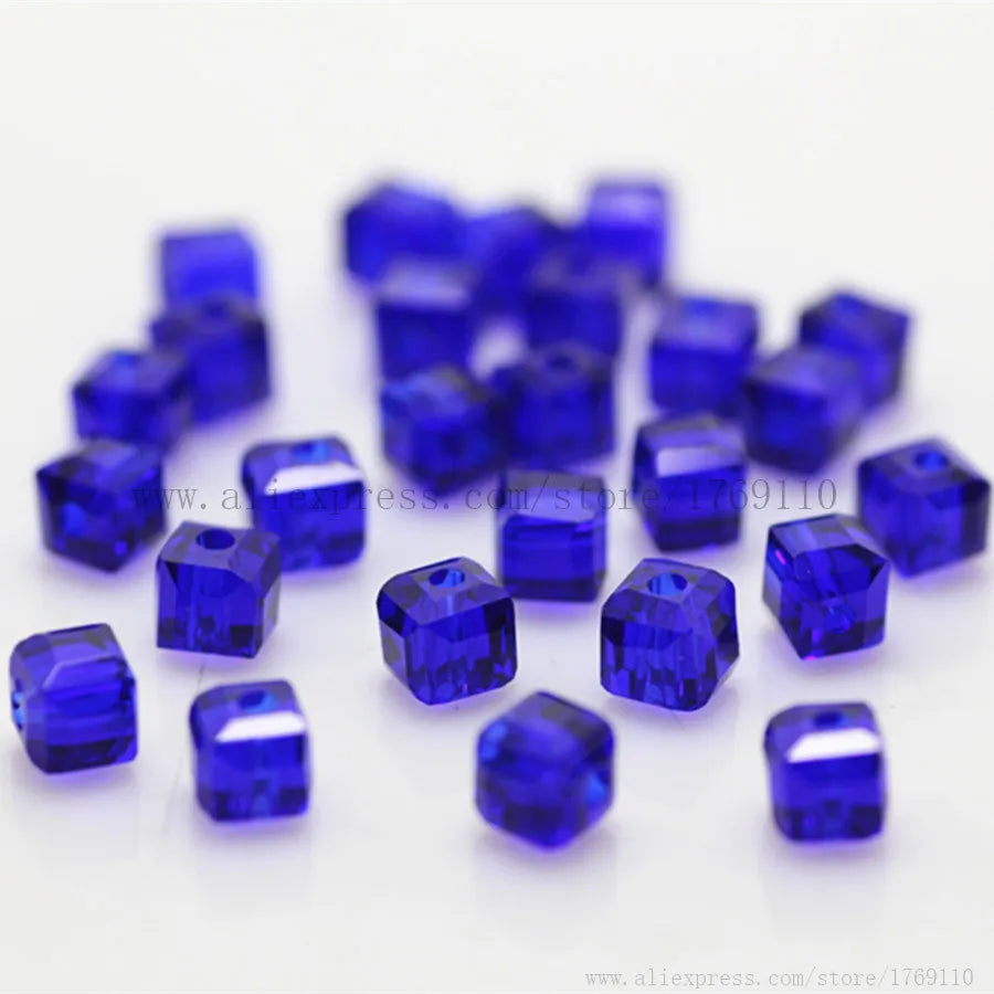 A collection of small, deep blue square cut glass crystal beads for jewelry making.
