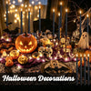 Halloween decorations featuring orange pumpkins, skulls, bats, and tall black taper candles with flickering LED flames.