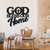 Art métal noir avec le texte 'GOD BLESS OUR HOME', accroché sur un mur blanc.