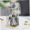A clear glass jar filled with various US dollar bills and coins on a white surface.