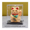 A small, solar-powered figurine of a pink and white cat with red ears and a gold collar, displayed in a clear plastic case.