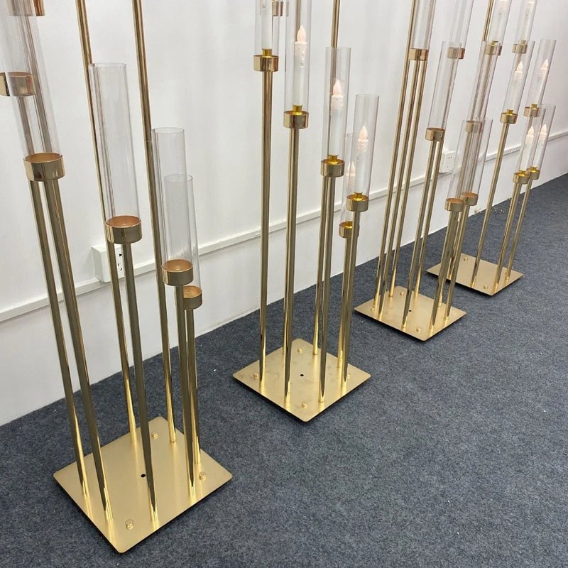 A set of gold metal candelabra with clear glass candle holders displayed on a gray carpet.