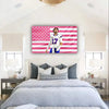 A wall hanging featuring a pink and white American flag design with a football player in a white jersey.