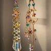 A delicate gold crystal suncatcher wind chime ornament featuring purple and blue gemstone charms.