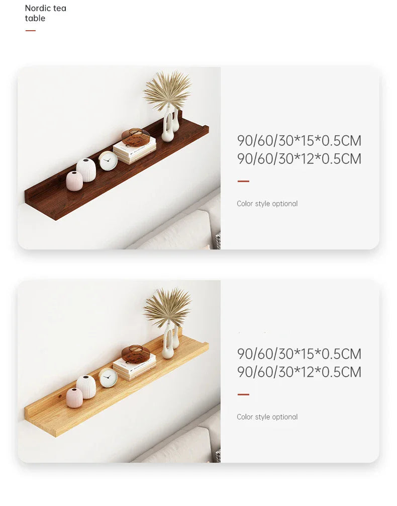 A natural wood floating shelf displaying a ceramic teapot, clocks, and dried floral arrangement on a white wall.