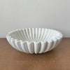 White lotus leaf resin decorative bowl with ribbed texture on a wooden surface