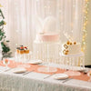 Elegant transparent acrylic cake display rack with white and pink tiered cakes decorated with gold accents