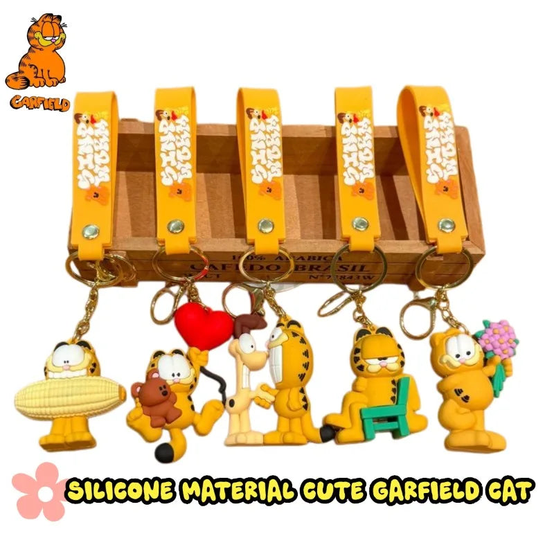 A set of cute Garfield cat keychains made of silicone material with a wooden display box.
