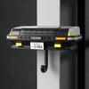 A black classic car headlight key holder with an LED illumination feature mounted on a white wall.