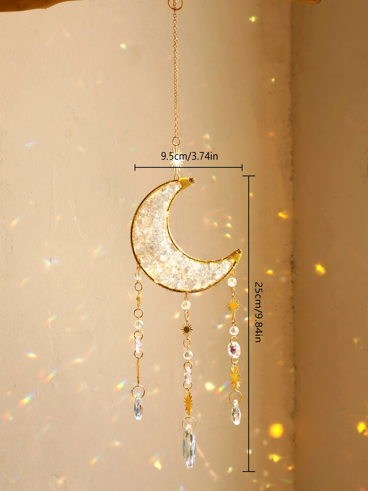 A hanging gold crescent moon dreamcatcher with dangling crystal beads and a rainbow prism.
