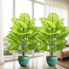 A set of two realistic artificial floor plants with large green leaves in potted containers near a window.