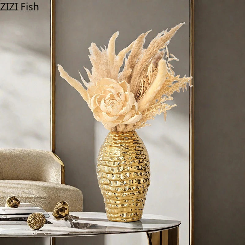 Golden wrinkle ceramic tabletop vase filled with dried grasses and botanicals