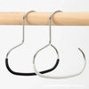 A silver round hook for hats, ties, scarves, and bags is hanging from a wooden rod.