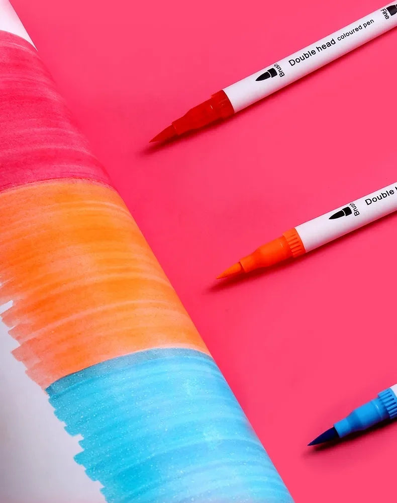 A set of dual-ended watercolor art markers showing various bright colors like orange, blue, and pink on a pink background.