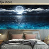 Schlafzimmer mit Bett aus grauer Bettwäsche vor einem Meer-Mural.