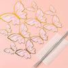 A set of pink and gold butterfly cake toppers scattered on a light pink background.