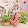 A collection of pink and green dinosaur-shaped balloons and decorations for a party.