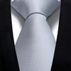 A close-up of a silver striped silk necktie worn under a black suit jacket.