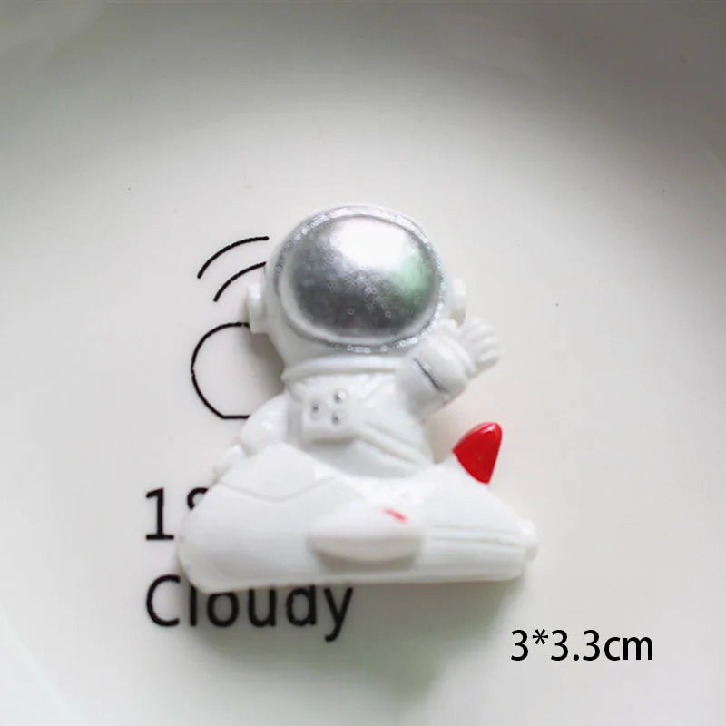 Miniature d'astronaute blanc avec casque argenté et accents rouges sur une assiette blanche.