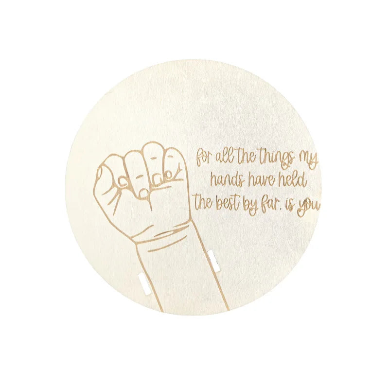 A light beige circular sign featuring a line drawing of a clenched fist and the text for all the things my hands have held th