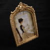 An ornate gold-framed vintage resin photo frame displaying a sepia-toned portrait of a woman.