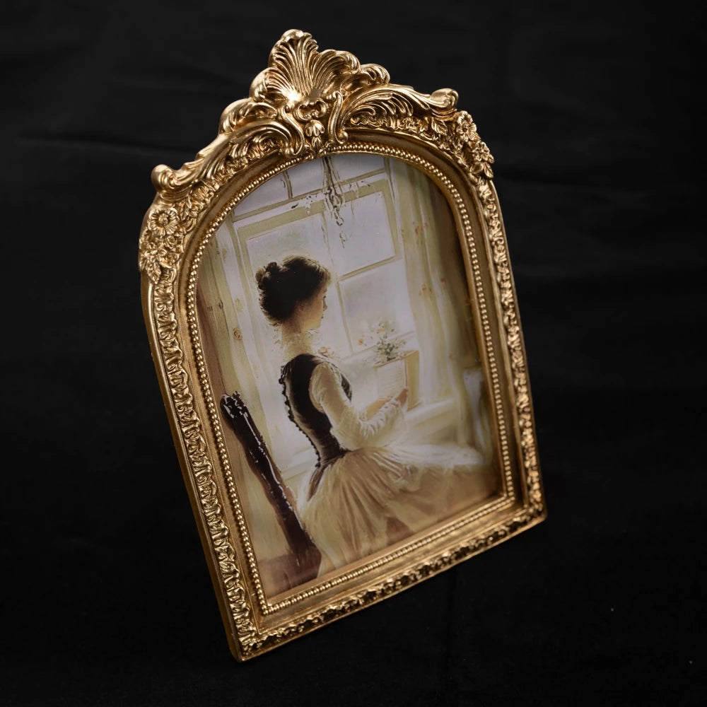 An ornate gold-framed vintage resin photo frame displaying a sepia-toned portrait of a woman.