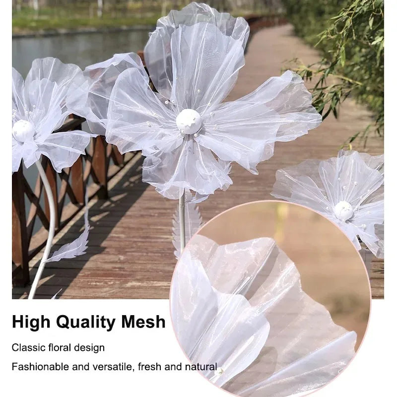 A set of three large, sheer white mesh flowers used as wedding or floral decoration.