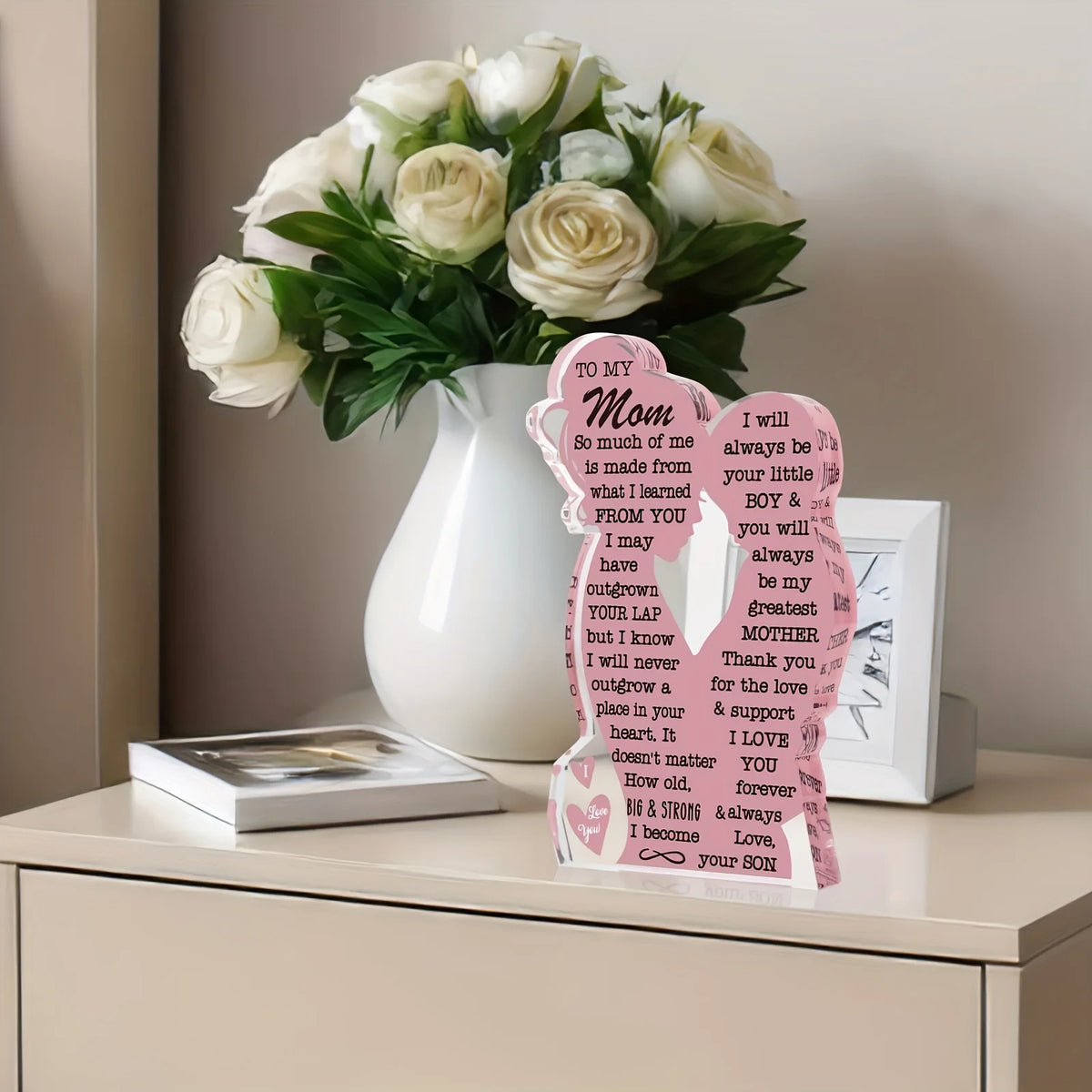A bouquet of white roses in a vase next to a personalized acrylic plaque for Mother's Day gifts