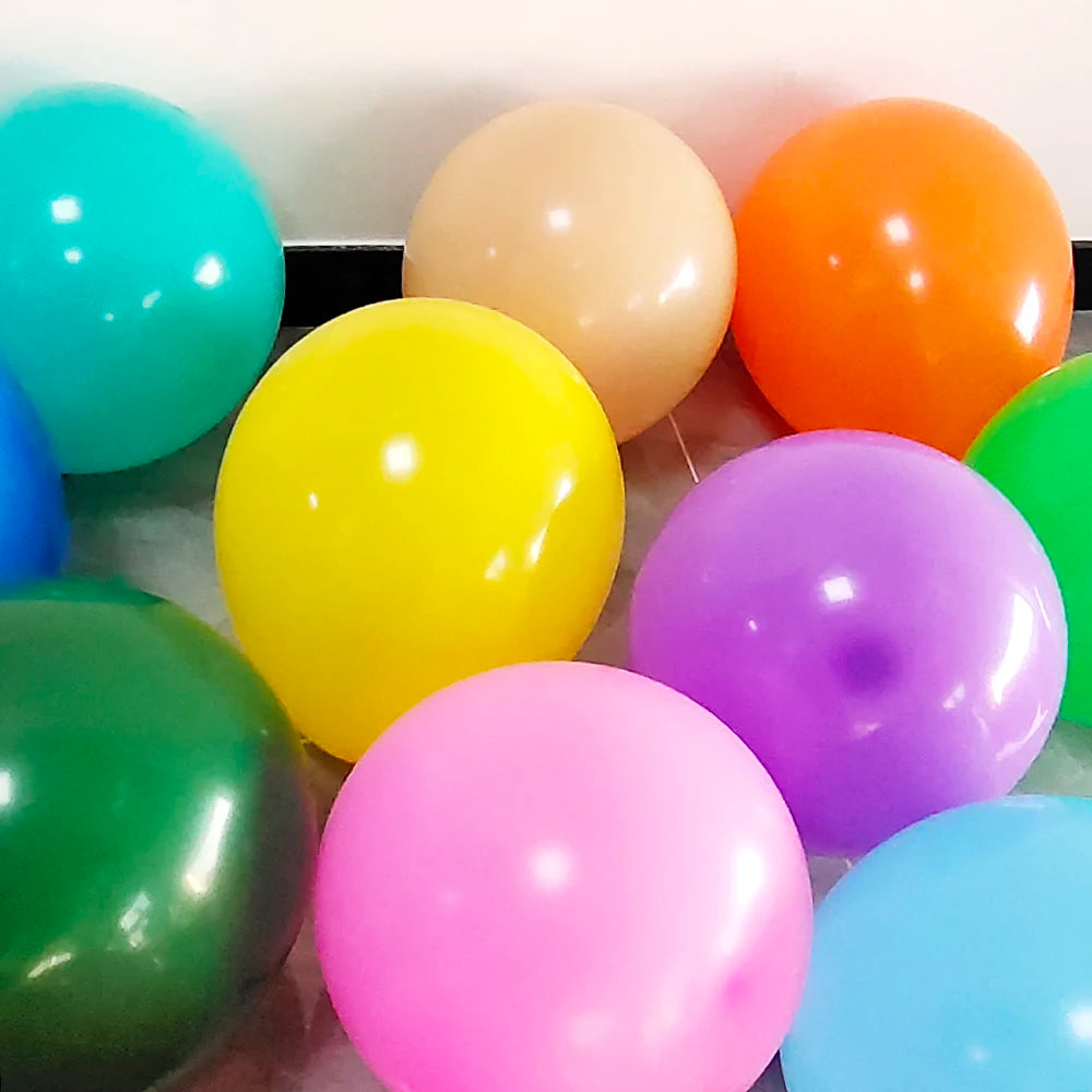 A collection of colorful matte latex balloons in shades of blue, green, yellow, orange, pink, and purple.