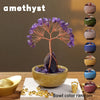 A crystal money tree with a rose quartz base and purple crystals displayed in a bowl.