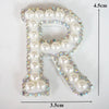 A white alphabet letter P patch decorated with clear and iridescent rhinestones.