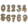A set of gold glitter number cake toppers featuring rhinestones and bow designs.
