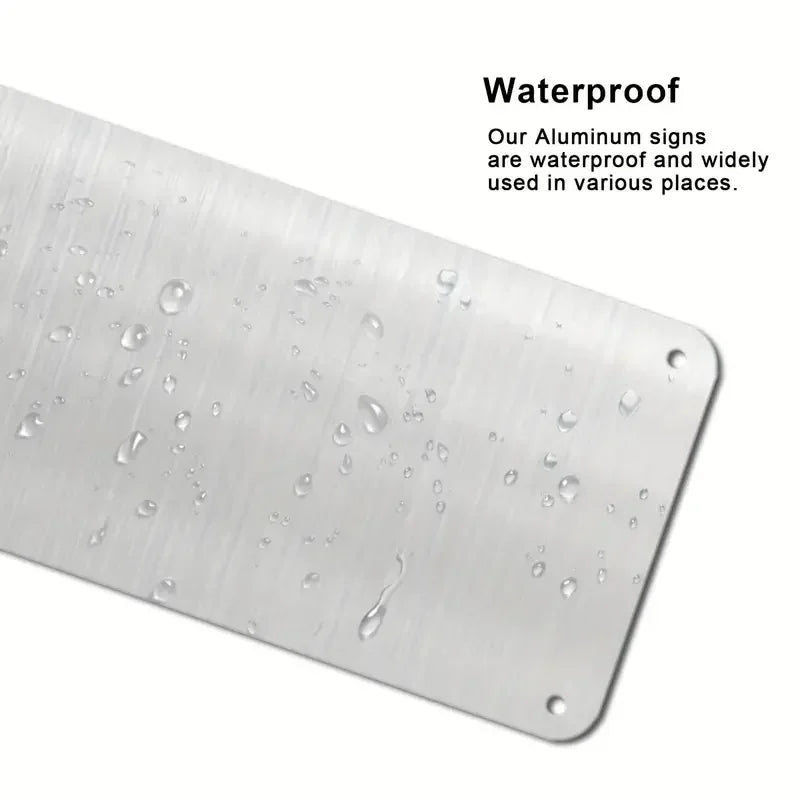 A close-up view of a silver aluminum sign with water droplets on it.