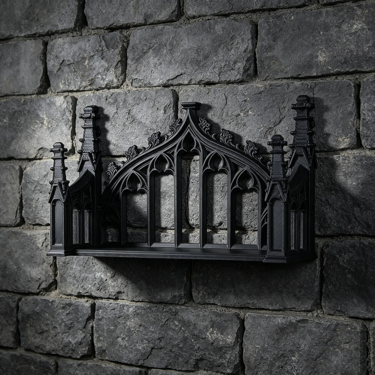 A black ornate Gothic wall shelf with intricate carvings mounted on a dark stone wall.