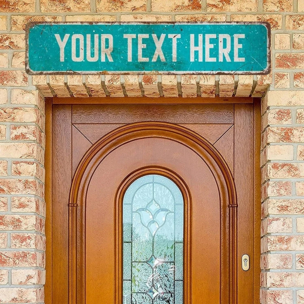 A brown wooden door with an arched glass panel and a teal sign above it on a brick wall.