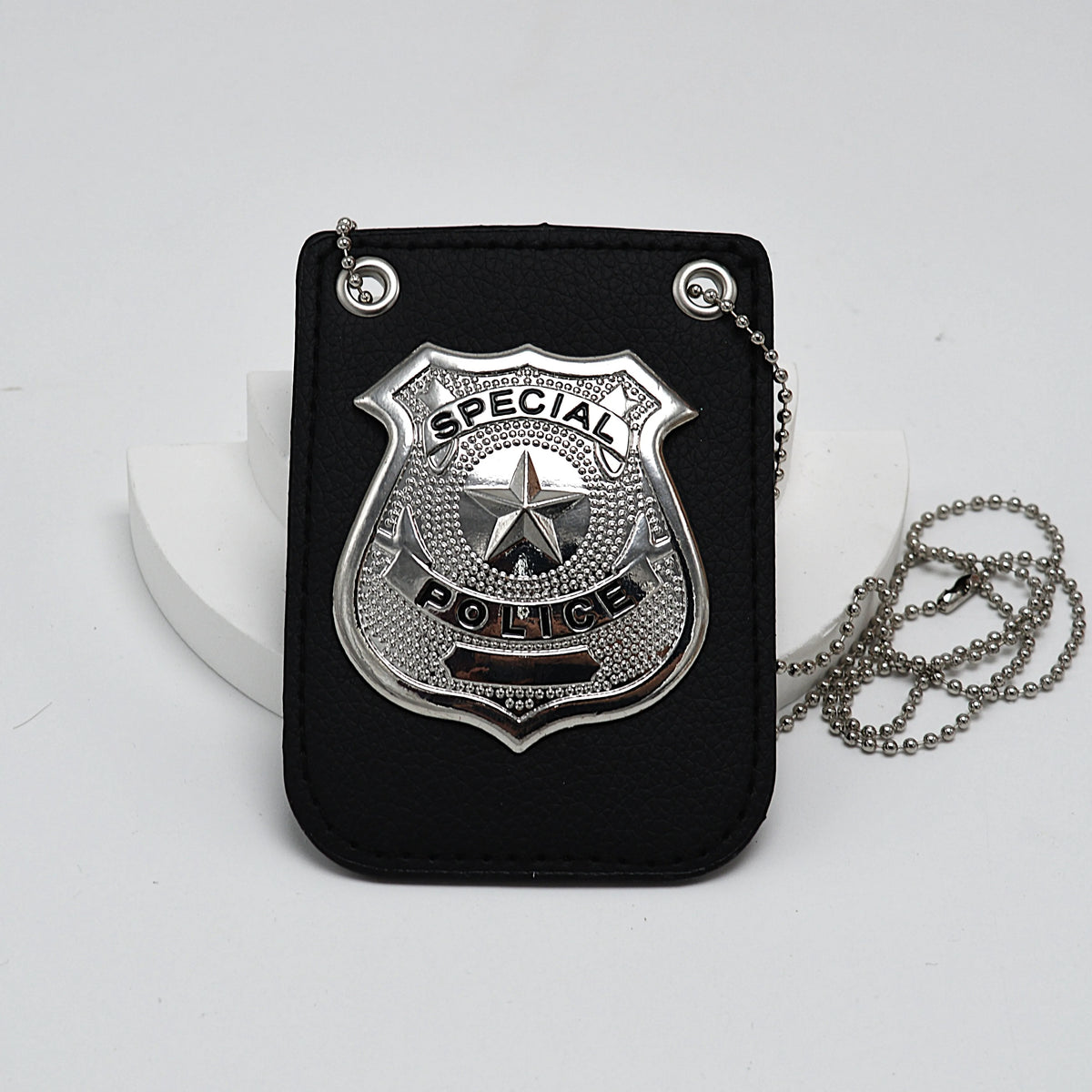 Porta credencial de cuero negro con placa policial plateada y cadena adjunta.