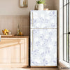 A white refrigerator with a light blue floral pattern is displayed next to wooden cabinetry.