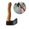 A wooden axe-shaped fridge magnet with a black handle and a green note attached.