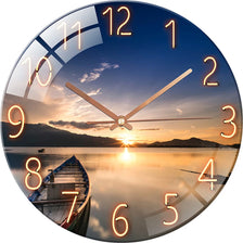 A round glass wall clock showing a sunset over water with numbers and hands.
