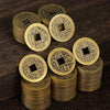 A stack of antique Chinese Feng Shui coins made of gold or brass, featuring traditional characters for wealth and good fortun